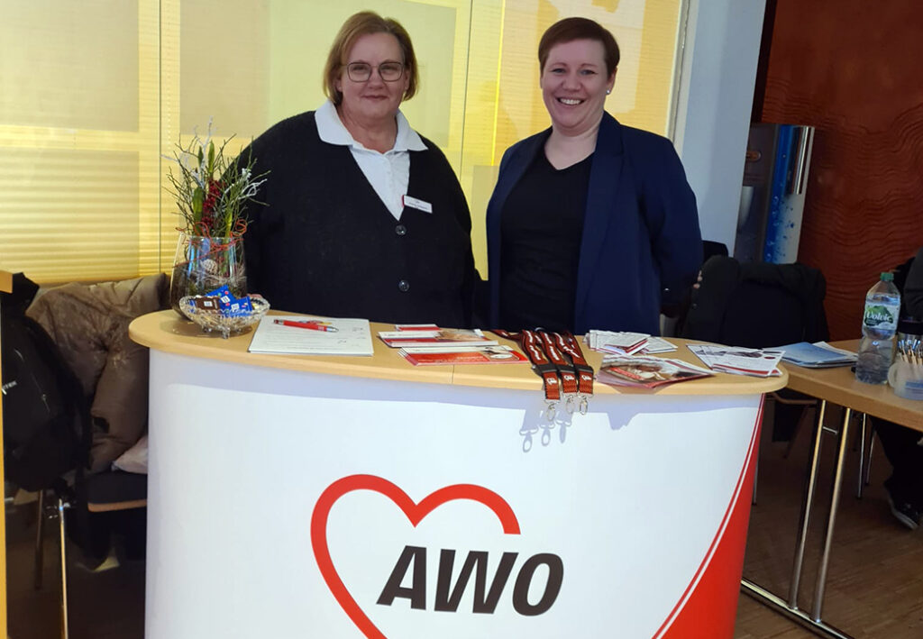 Zwei Frauen stehen hinter einem AWO-Informationsstand.