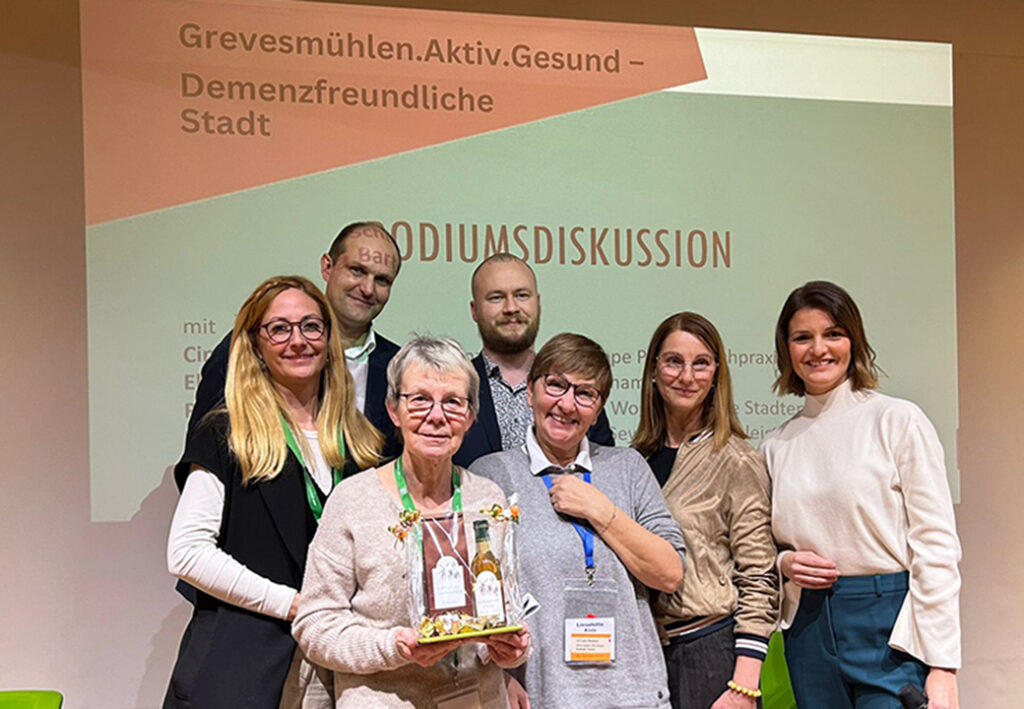 Sieben Personen posieren f&uuml;r ein Foto vor einem Projektionshintergrund