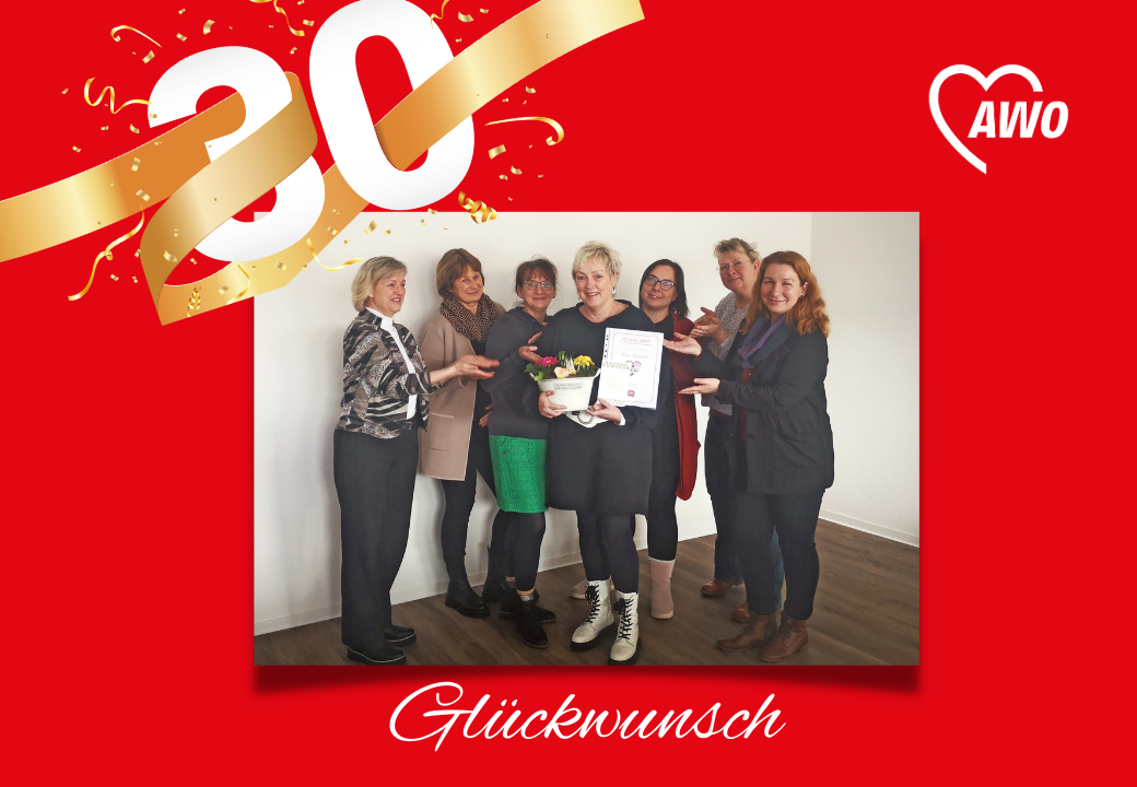 Eine Gruppe von Frauen feiert das 30-jährige Bestehen einer Organisation mit einer Urkunde und Blumenstrauß.