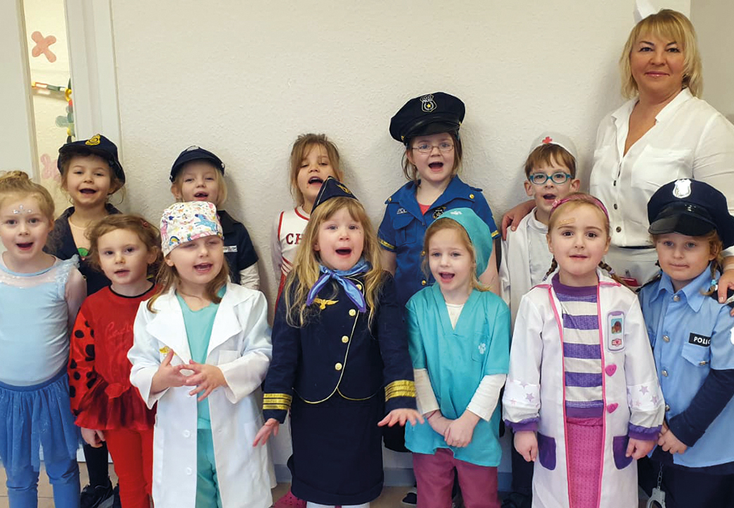 Gruppe von Kindern in Kostümen mit einer Erwachsenen