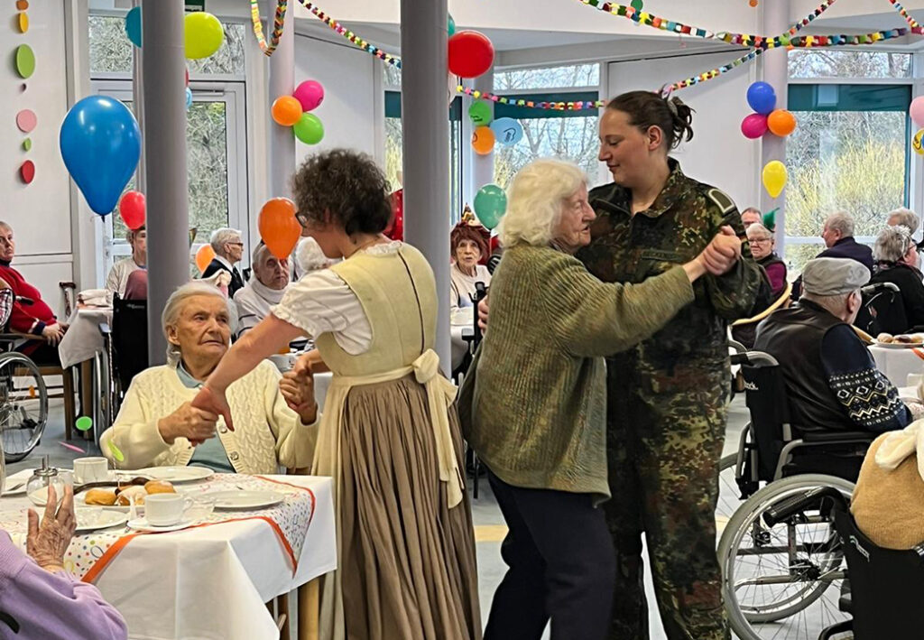 Personen tanzen bei einer Feier in einem Altersheim