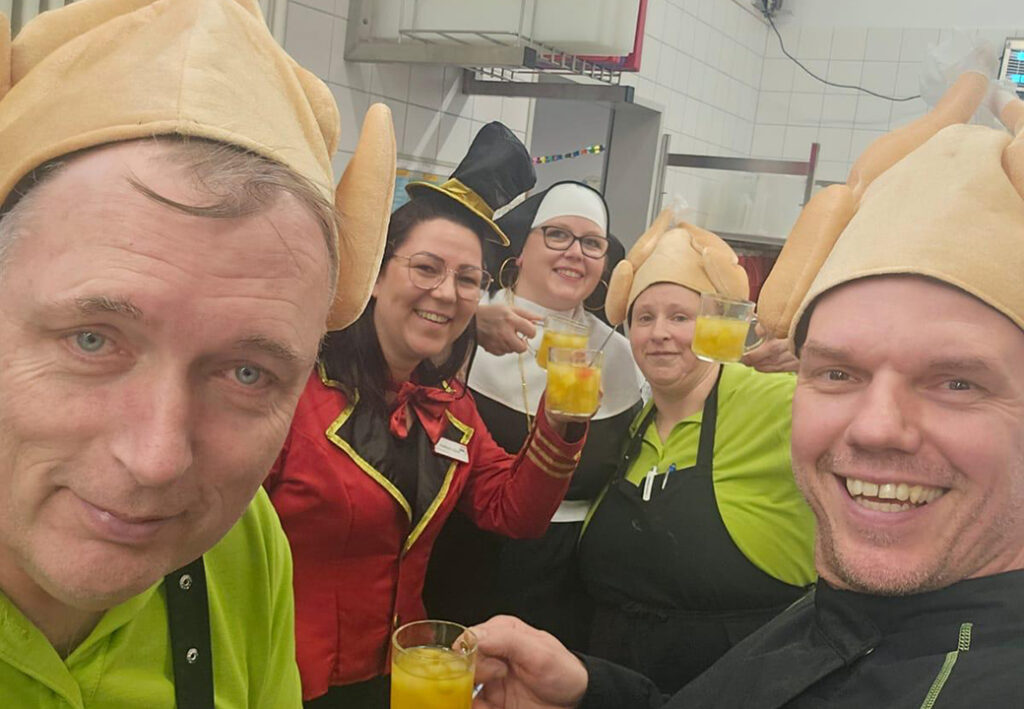 Gruppe von Menschen in Verkleidung, die Getr&auml;nke halten.