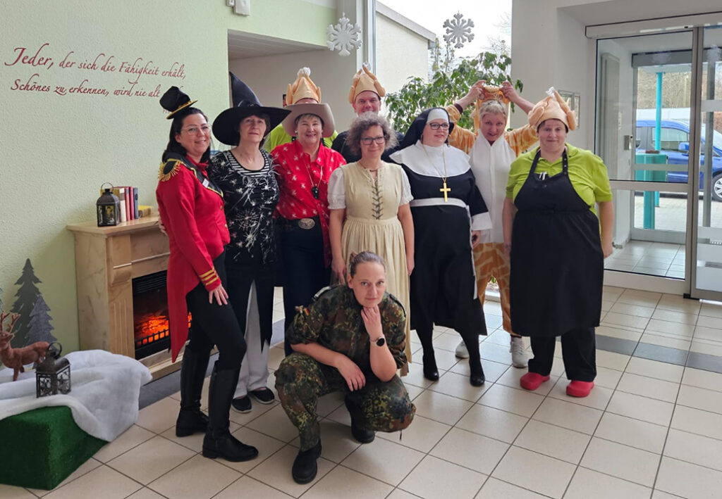 Eine Gruppe von Menschen in Kost&uuml;men steht in einem Raum zusammen.