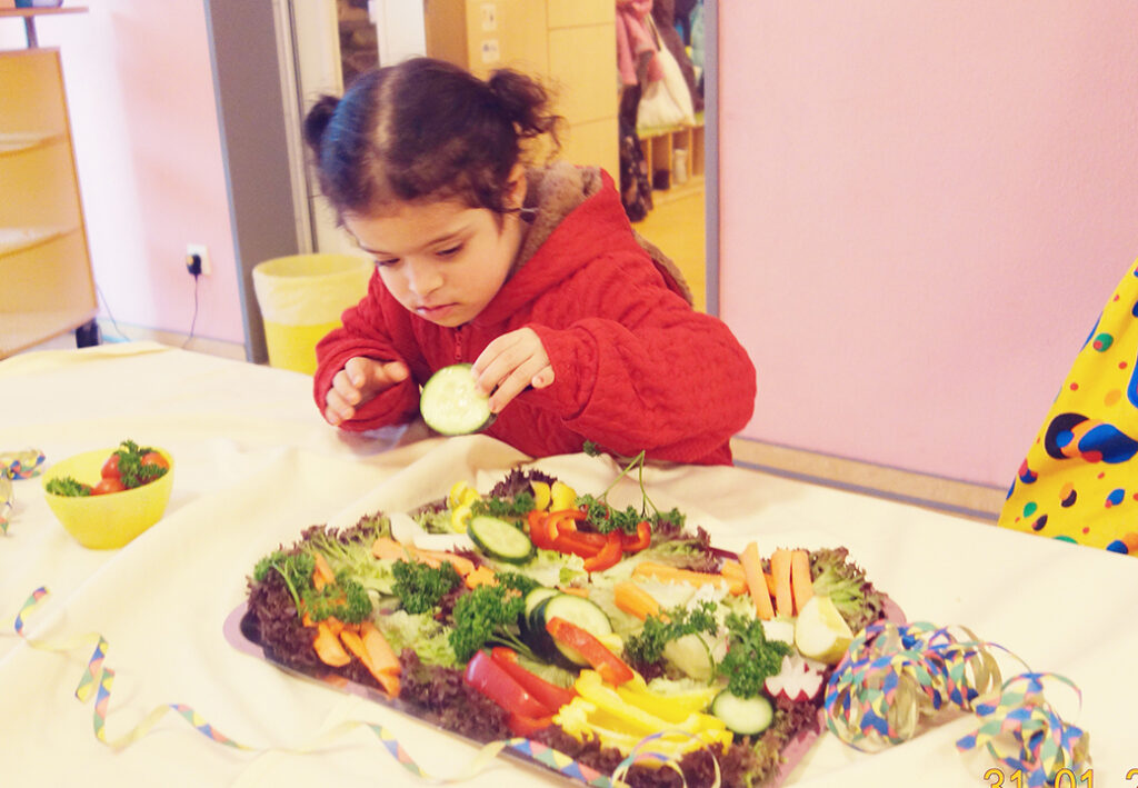 Kind betrachtet Gem&uuml;seplatte