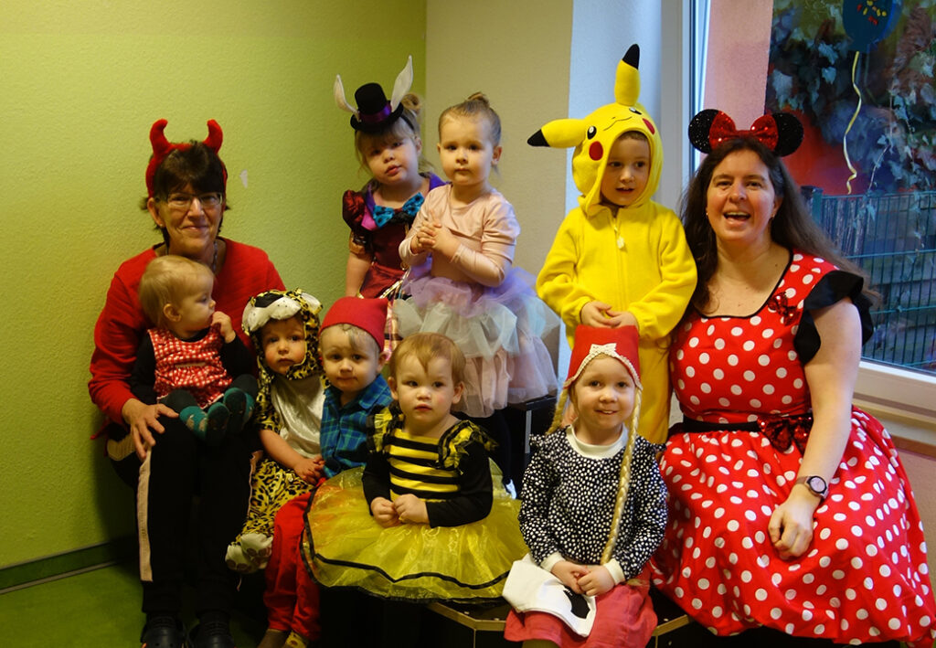 Eine Gruppe von Kindern und Erwachsenen in bunten Kost&uuml;men