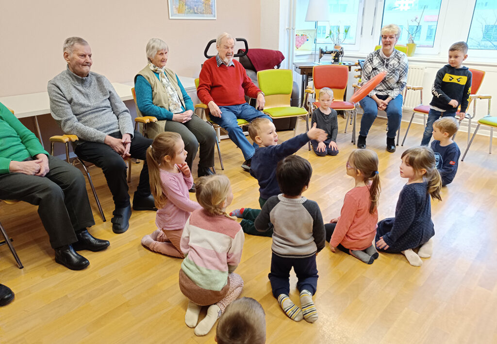 Gruppenaktivit&auml;t in einem Raum mit Senioren und Kindern