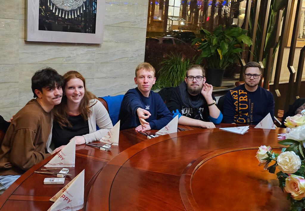 Gruppe junger Menschen, die an einem runden Tisch sitzt