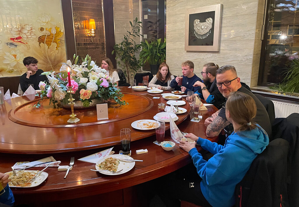 Gruppe von Menschen bei einem Essen an einem runden Tisch in einem Restaurant