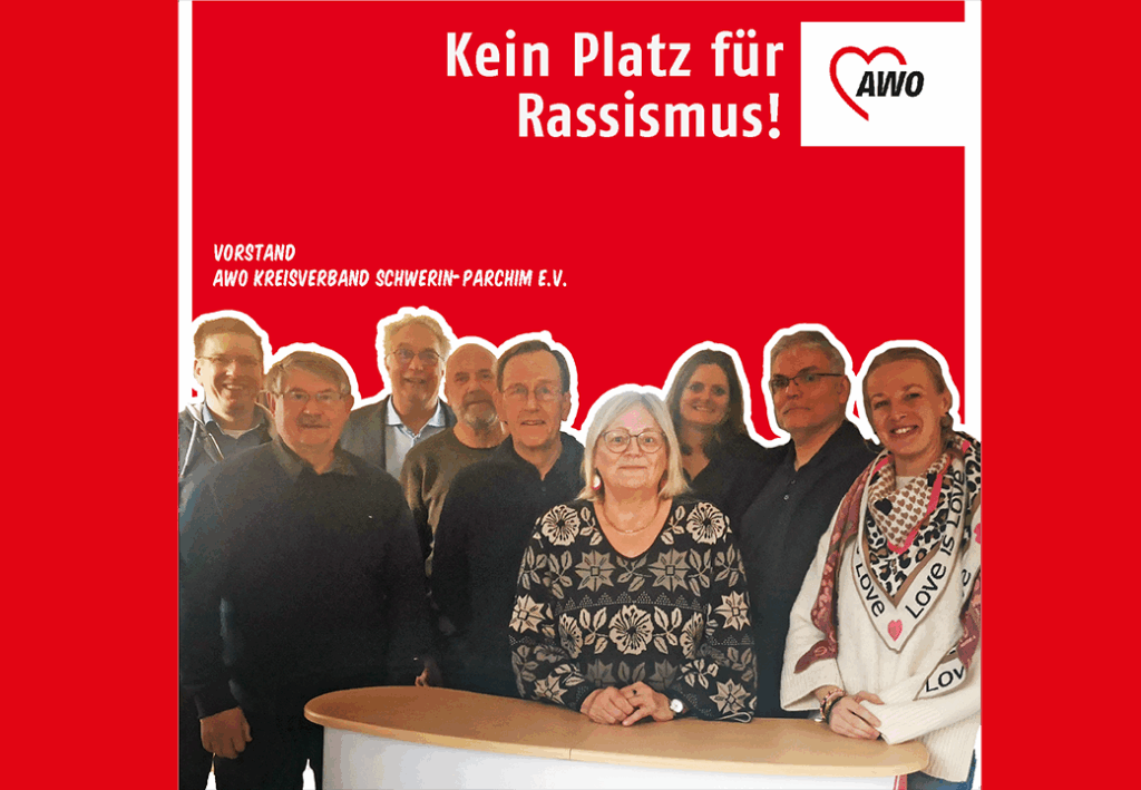 Foto des Vorstands der AWO Kreisverband Schwerin-Parchim e.V. vor rotem Hintergrund mit der Aufschrift 'Kein Platz f&uuml;r Rassismus'.
