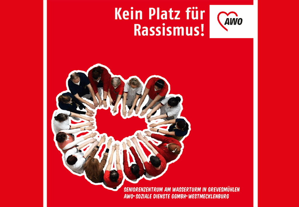 Eine Gruppe von Menschen steht im Kreis und streckt die Arme nach innen auf einem roten Hintergrund. Dar&uuml;ber steht 'Kein Platz f&uuml;r Rassismus!' mit einem AWO-Logo.
