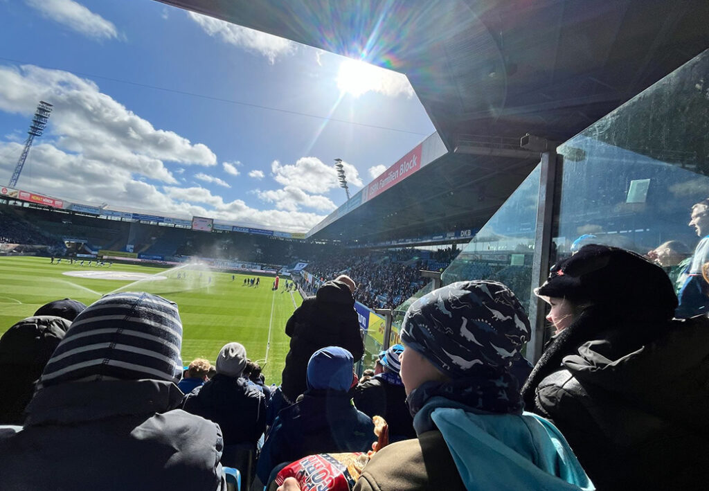 Besucher in einem Fu&szlig;ballstadion w&auml;hrend eines Spiels.