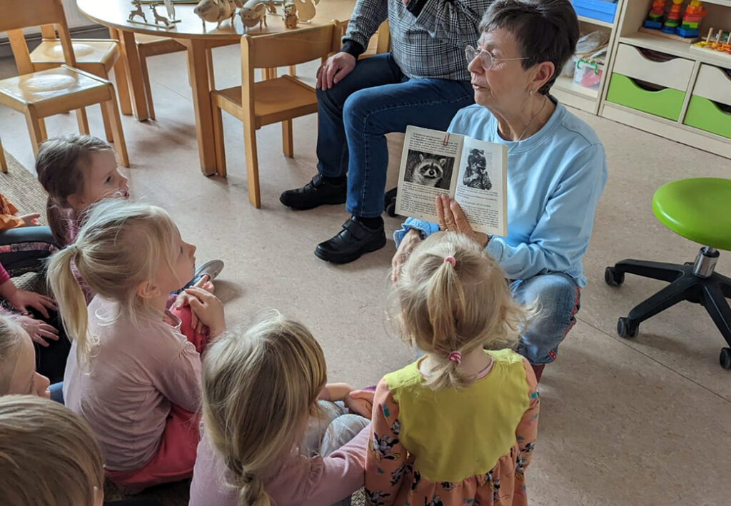 &Auml;ltere Frau liest einer Gruppe von Kindern vor