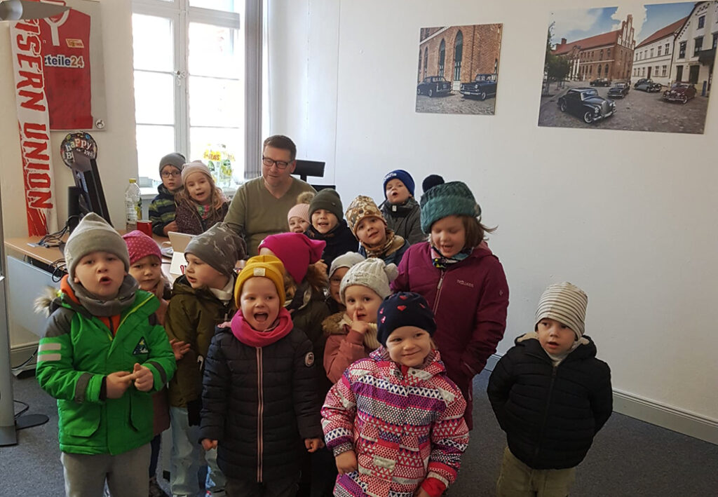 Gruppe von Kindern und einem Erwachsenen in einem B&uuml;ro