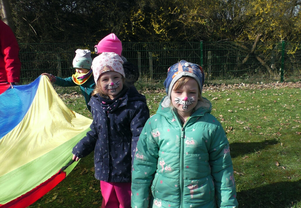 Kinder mit Katzenschminke beim Spielen im Freien