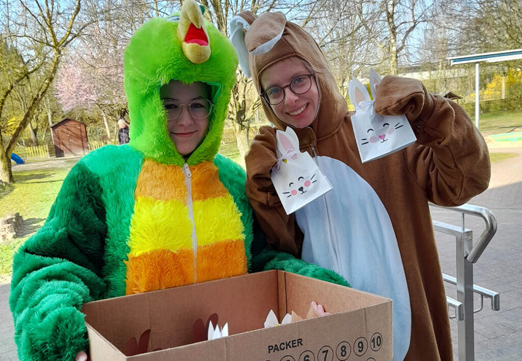 Zwei Personen in Tierkostümen, eine als grüner Papagei und die andere als brauner Hase verkleidet.