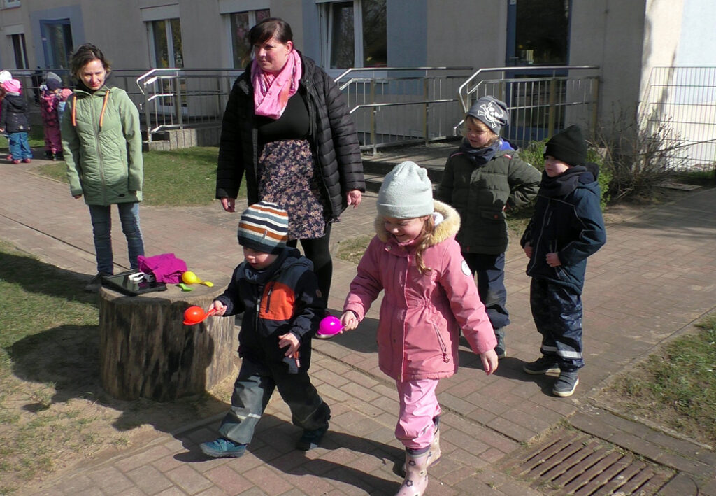 Kinder spielen ein drau&szlig;en Spiel mit Betreuerinnen