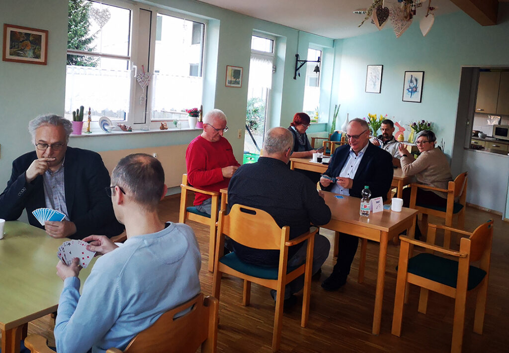 Menschen, die in einer Gruppenaktivit&auml;t Karten spielen