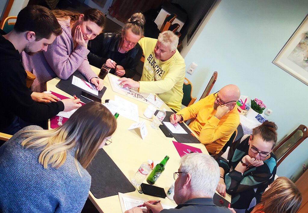 Gruppe von Menschen bei einem gemeinsamen Treffen an einem Tisch.