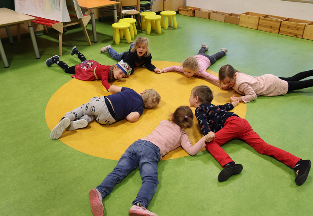 Kinder spielen im Kreis auf dem Boden