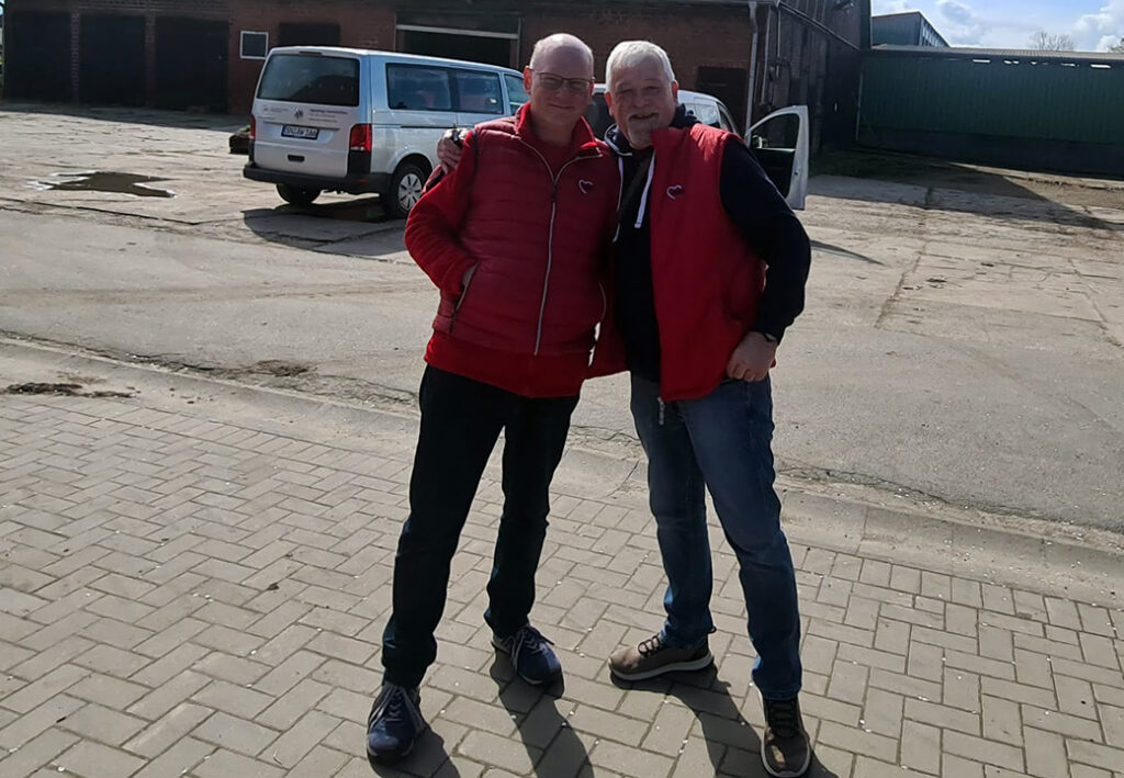 Zwei M&auml;nner in roten Westen posieren zusammen