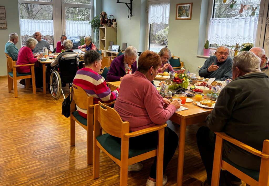 Menschen in einem Gemeinschaftsraum beim Essen