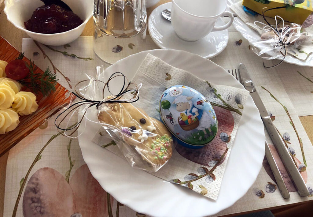 Fr&uuml;hst&uuml;ckstisch mit gedecktem Teller und Osterdekoration