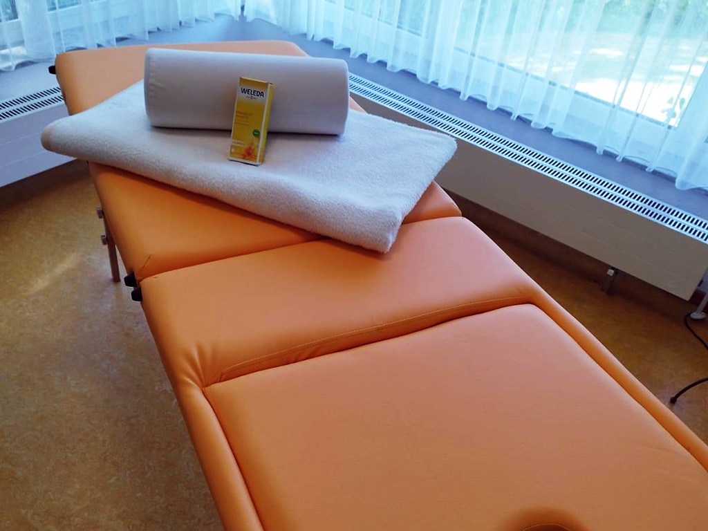 Massageliege mit Handtuch und Massageöl