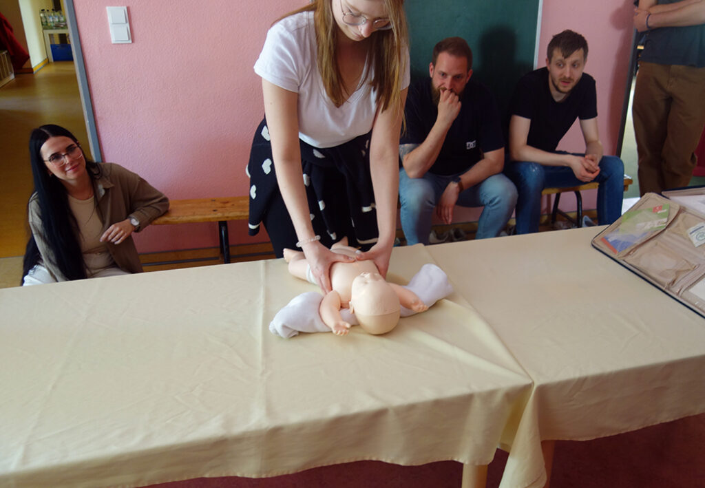 Person führt Erste Hilfe an Puppenbaby durch