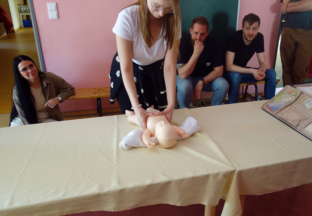 Person führt Erste Hilfe an Puppenbaby durch