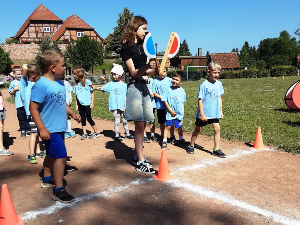 Kinder bei Outdoor-Spiel mit Erwachsener
