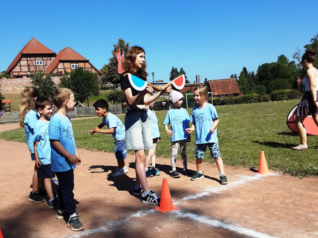 Gruppe von Kindern und einer Betreuerin bei einer Outdoor-Aktivit&auml;t.