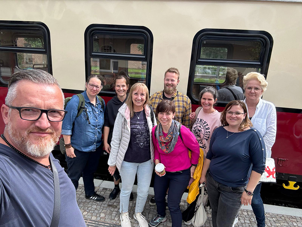 Eine Gruppe von Menschen steht vor einem Zug.