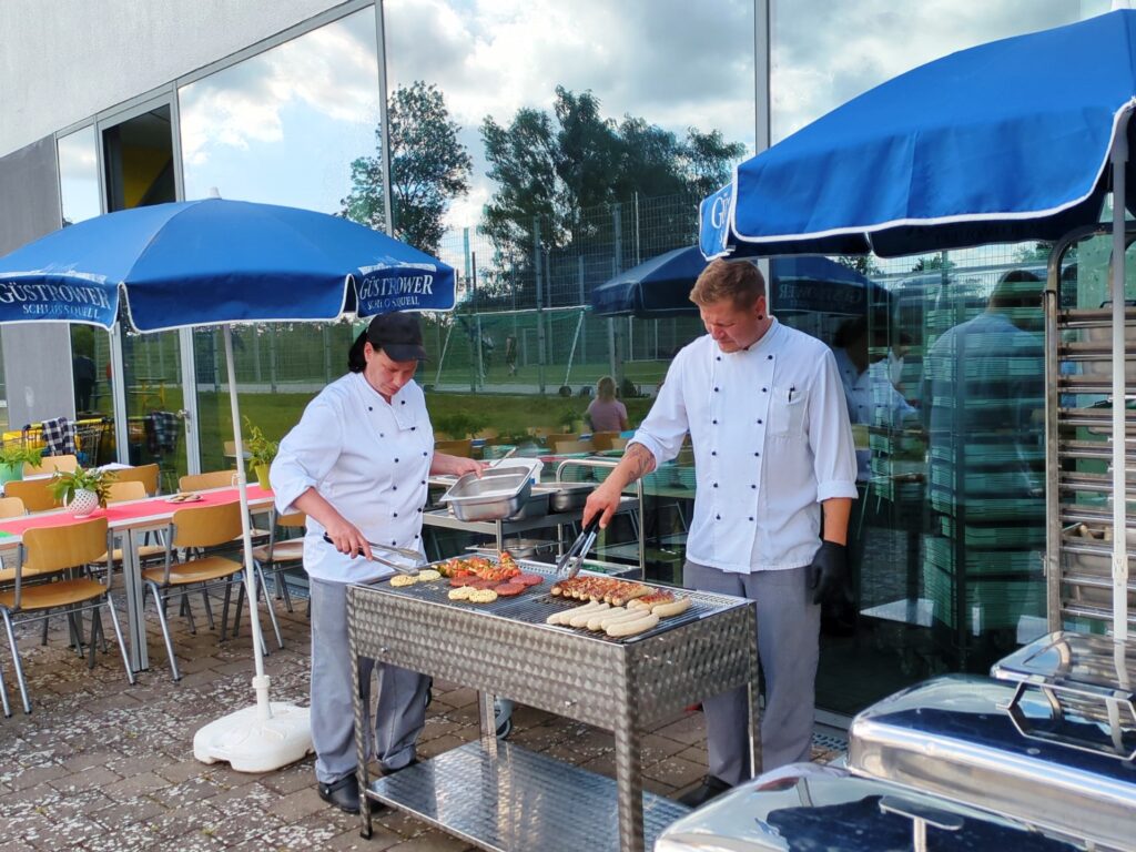 Zwei Personen beim Grillen im Freien.