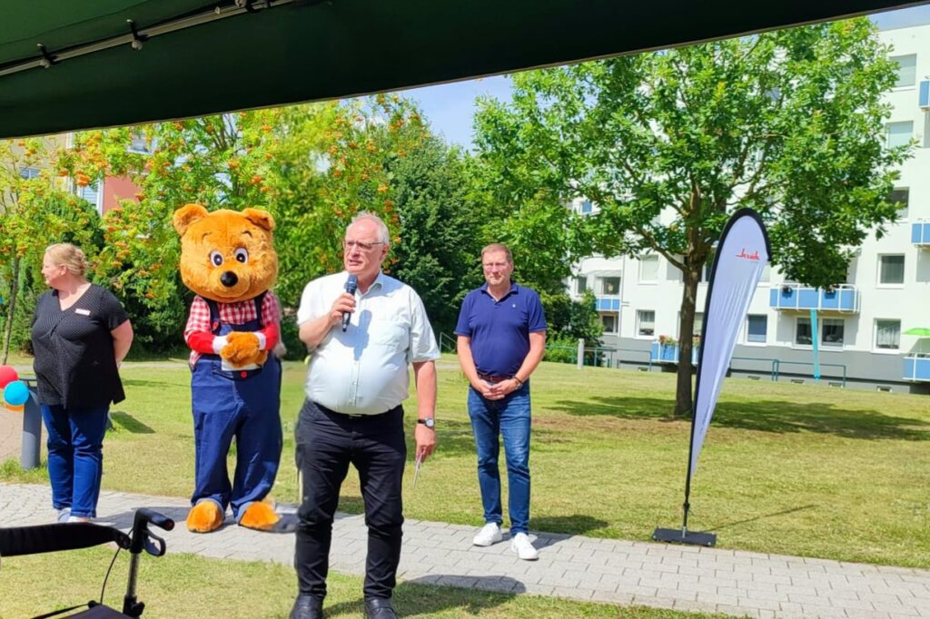 Menschen bei einer Outdoor-Veranstaltung mit einer Person in einem Bärenkostüm