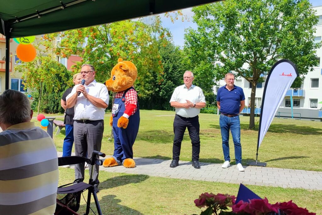 Menschengruppe bei einer Outdoor-Veranstaltung mit Maskottchen