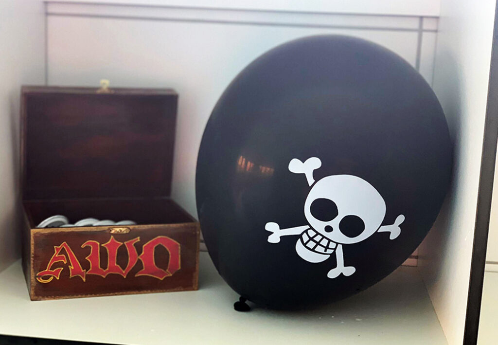 Schwarzer Ballon mit Totenkopfdesign und h&ouml;lzerne Schachtel mit 'AWO' Aufschrift
