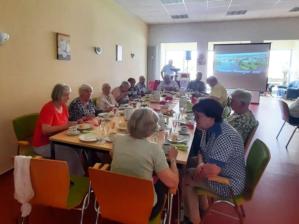 Gruppe von Menschen bei einer Zusammenkunft an einem Tisch.