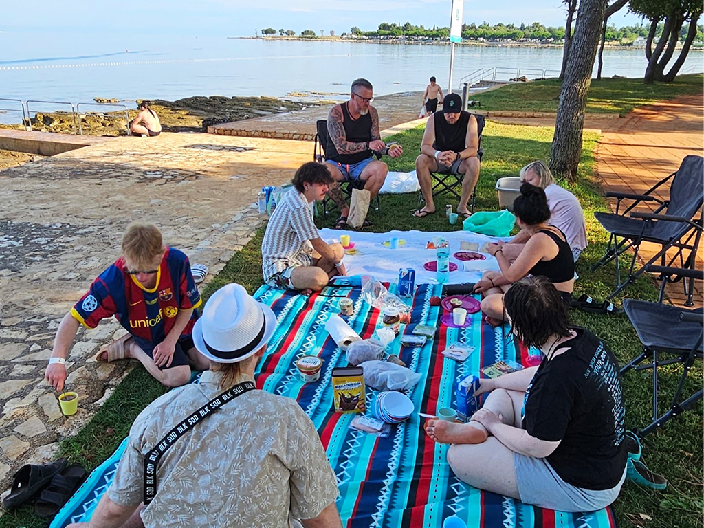 Menschen sitzen bei einem Picknick am Strand