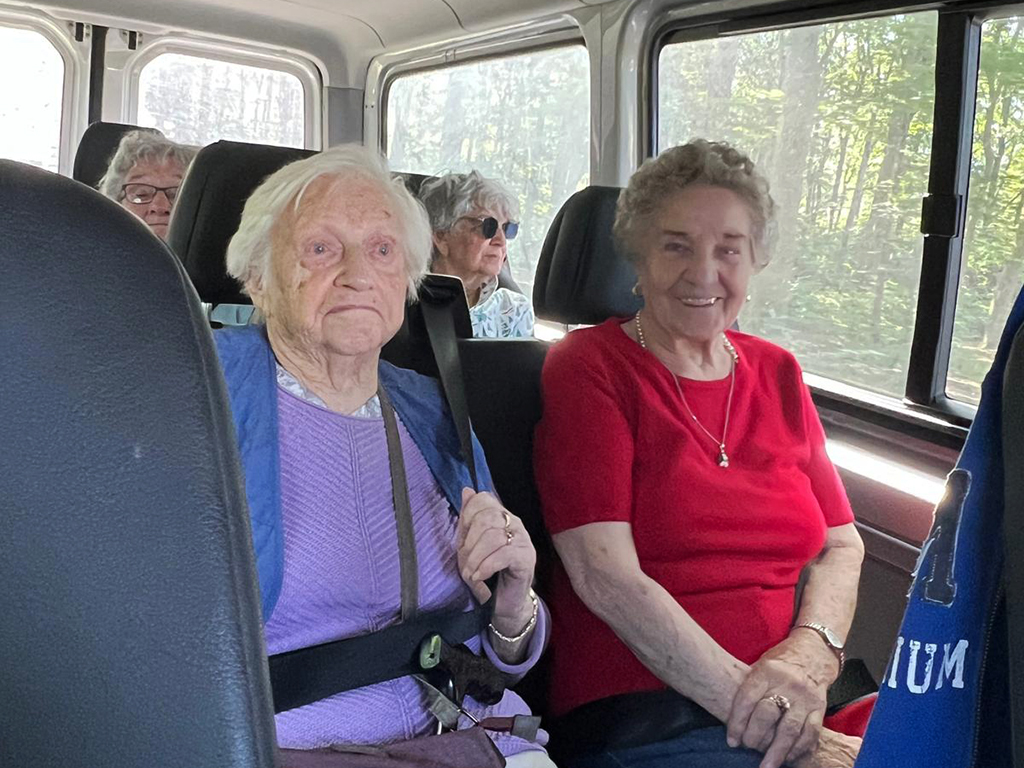 Eine Gruppe älterer Menschen sitzt in einem Kleinbus.