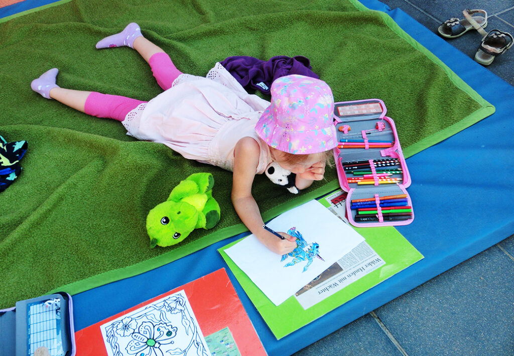 Kind malt ein Bild mit farbigen Stiften