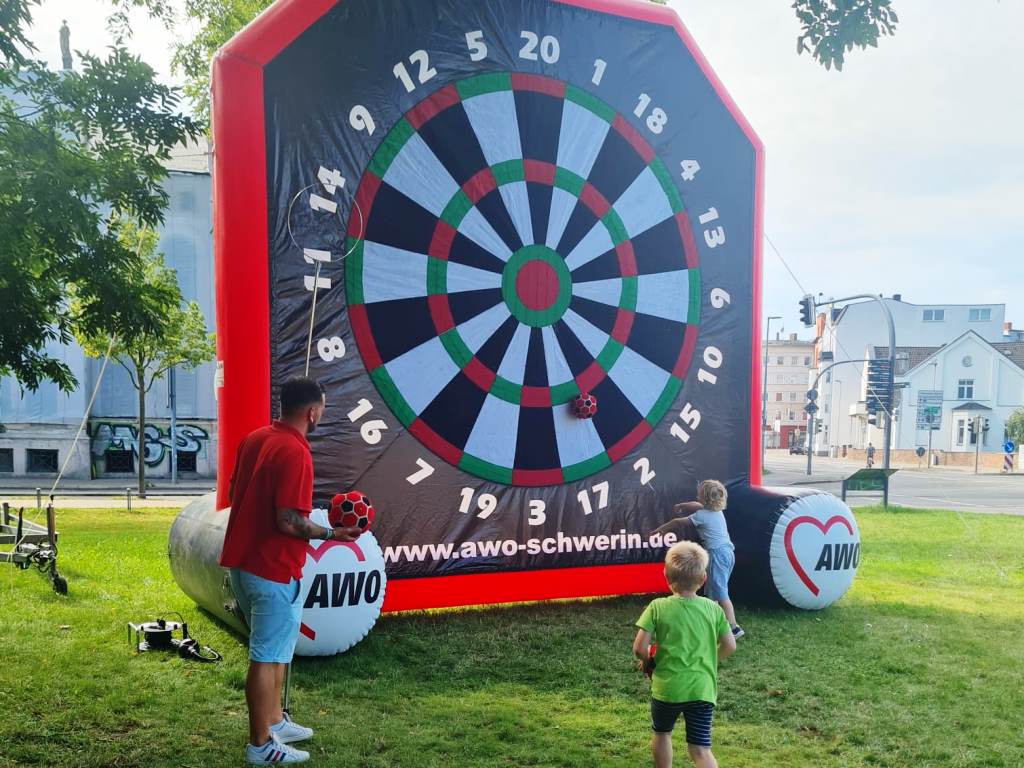 Aufblasbare Dartscheibe mit Kindern und einem Erwachsenen im Freien