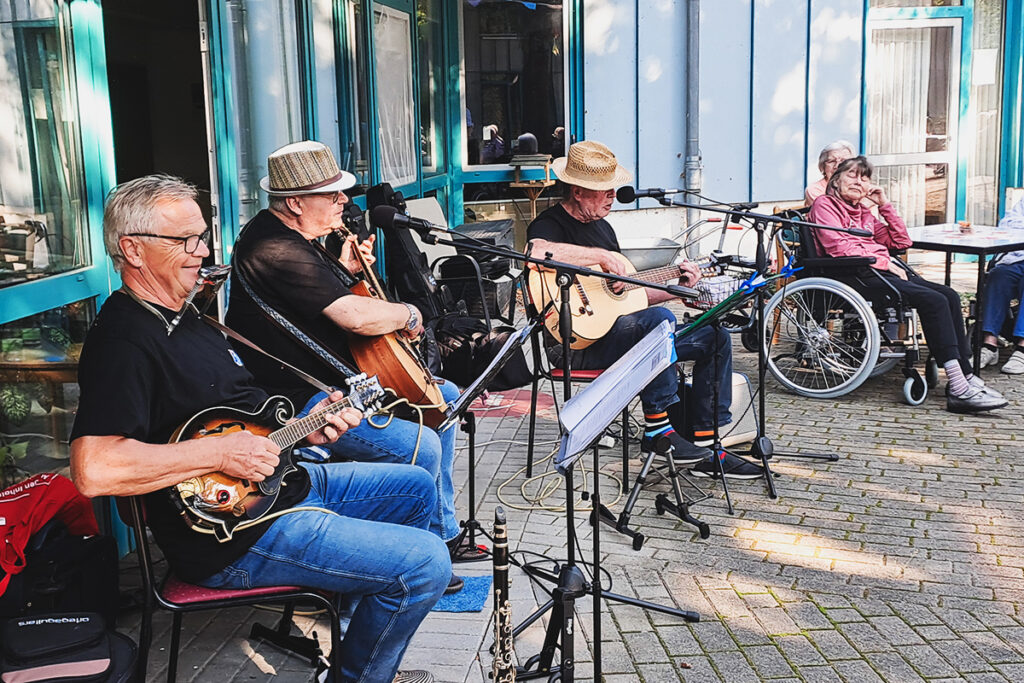 Musiker spielen im Freien für Senioren.