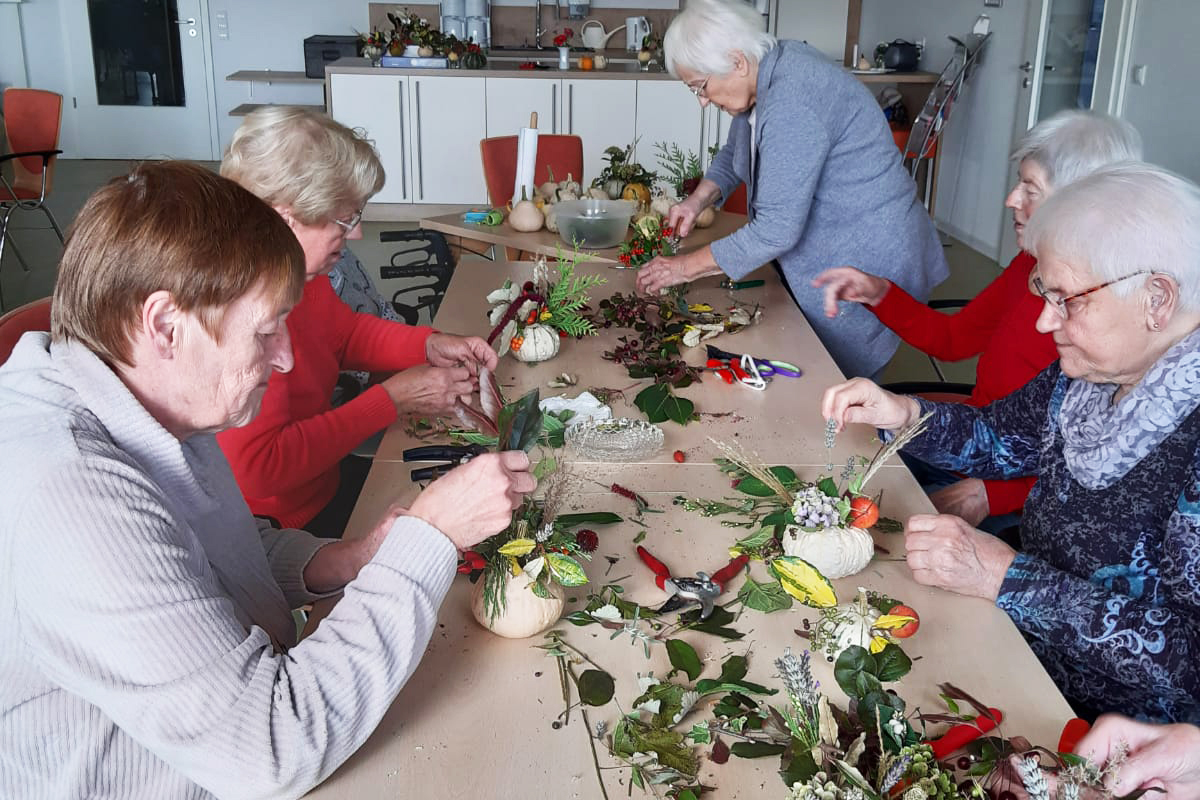 Senioren basteln gemeinsam an einem Tisch
