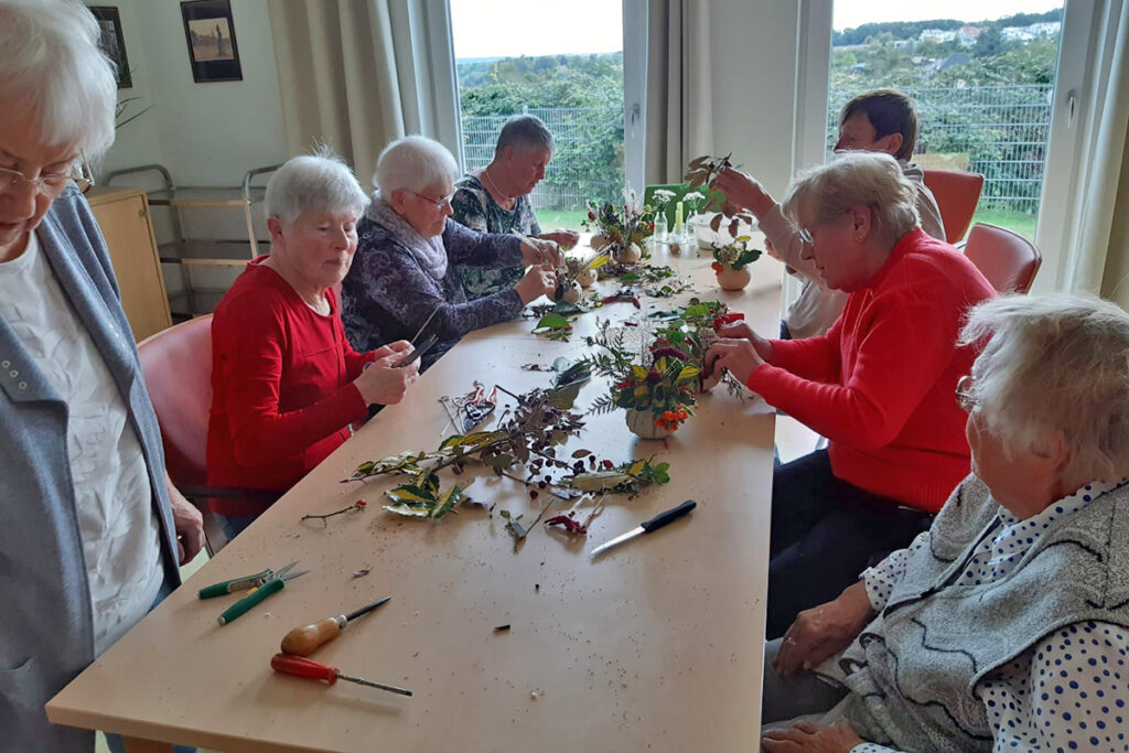 &Auml;ltere Menschen beim Basteln von Blumengestecken