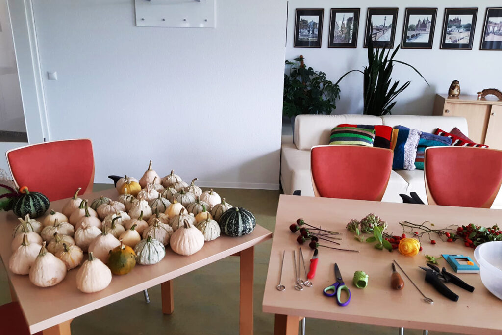 Raum mit zwei Tischen, K&uuml;rbisse und Bastelmaterialien