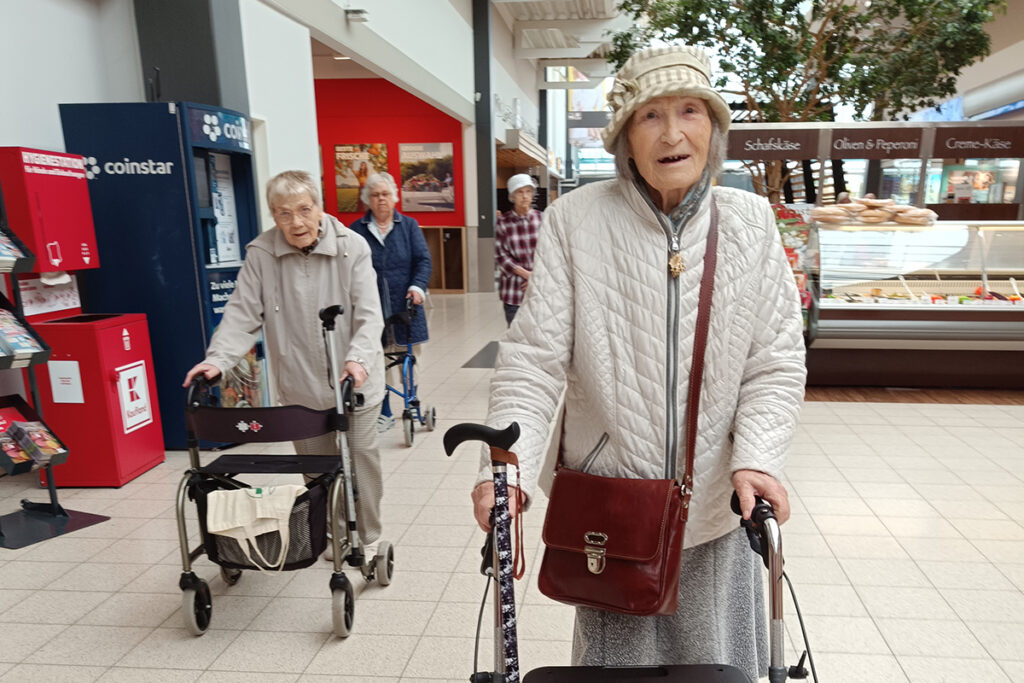 Drei &auml;ltere Frauen mit Rollatoren in einem Einkaufszentrum