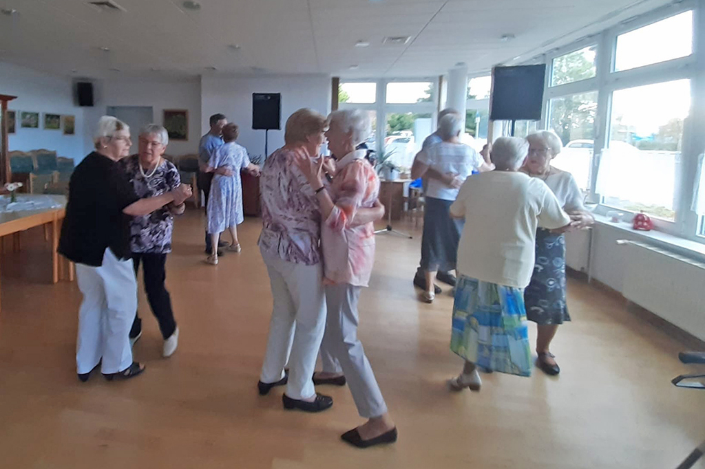 Ältere Menschen tanzen in einem Saal.