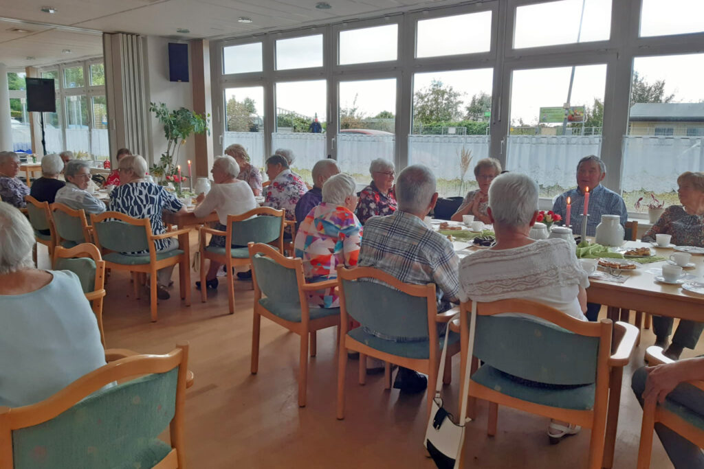 Seniorengruppe sitzt in einem Gemeinschaftsraum