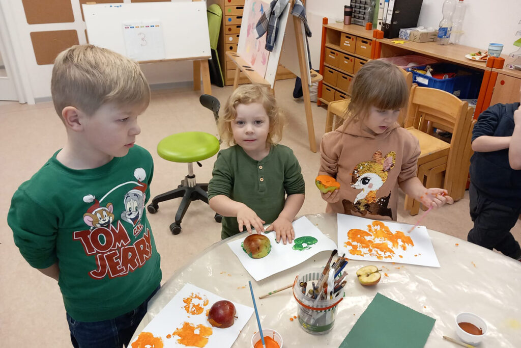 Kinder beim Basteln mit Farbe und Papier