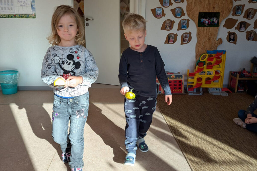 Zwei Kinder in einem Raum mit Spielzeug.